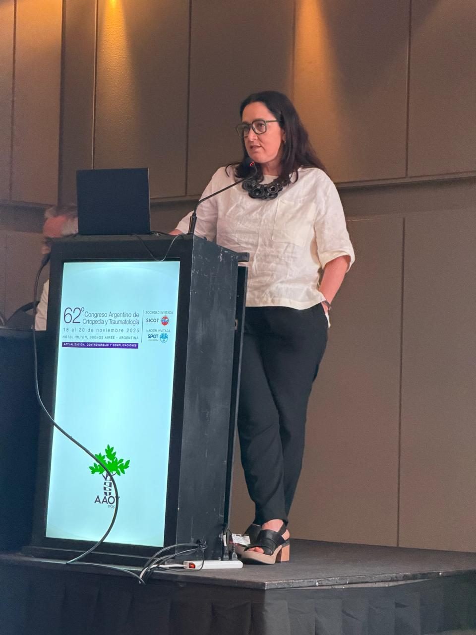 Disertante en el 62° Congreso Argentino de Ortopedia y Traumatología 2025, con el atril de AAOT